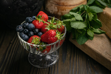 Berries in a bowl on a wooden table. Strawberries and blueberries
