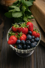 Berries in a bowl on a wooden table. Strawberries and blueberries
