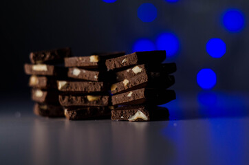 Naklejka premium milk chocolate with nuts, garland in the background