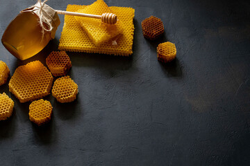Honey with honeycomb on black table, top view. space for text