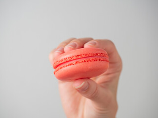 Orange sweet macaroon cookies in hand on a white background. Close-up, air-conditioning product