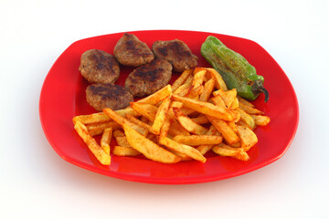 meatballs and potatoes on a red plate on white background