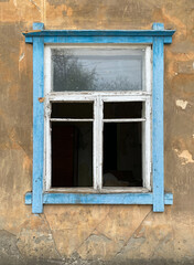 Broken window of an old house. The house is ready for demolition. Blue frame