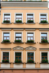 Fototapeta premium Facade of an old European house with windows and decorated with flowers