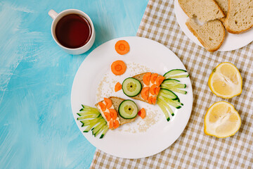 Funny sandwiches in form of fish on blue background. Breakfast for children. Natural
