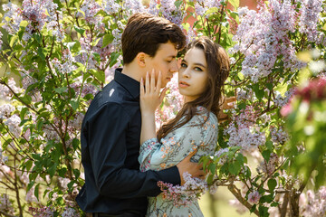 young beautiful couple  hugging in lilac flowers.