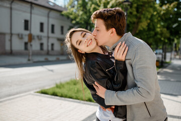 Fototapeta premium young happy beautiful couple laughing and hugging in the street. .