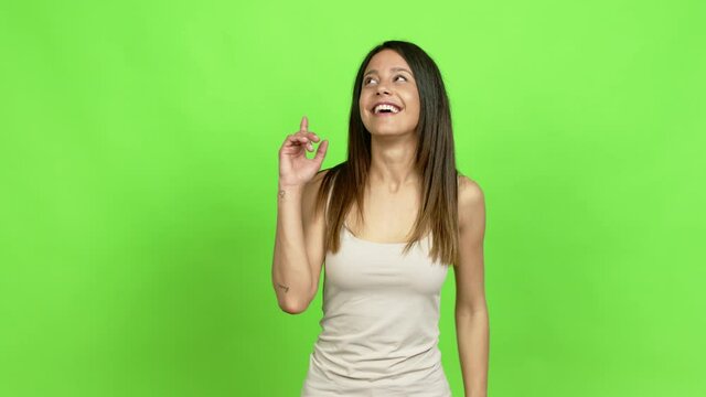 Young woman intending to realizes the solution while lifting a finger up over isolated background