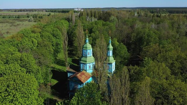 Aerial View of wooden church surrounded by high old trees. Pereyaslav-Khmelnitsky Museum of Folk Architecture and Life of the Middle Naddnipryanshchyna.