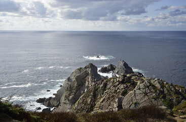 The sky and the sea come together in front of the cliffs of a cape