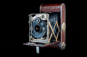 Vintage folding camera isolated on the black background. Close shoot of the folding camera from 1930. 