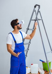 Man with VR glasses gluing wallpaper