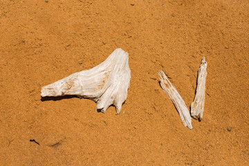 Full frame of beach or desert sand with skeleton-like sticks. Archeology excavation concept