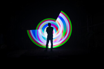 One person standing alone against beautiful color circle LED light painting as the backdrop