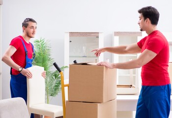 Two contractor employees moving personal belongings