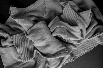 grey v neck sweater - photographed from above with low or raking light - emphasis on texture and folds