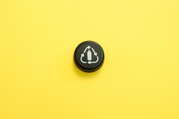 Bottle cap recycle logo on a yellow background 