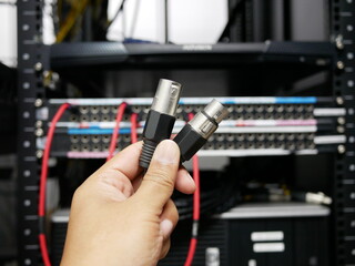 hand holding XLR cable connector at TV station.