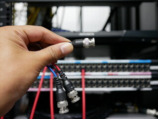 hand holding BNC cable connector in the TV station.
