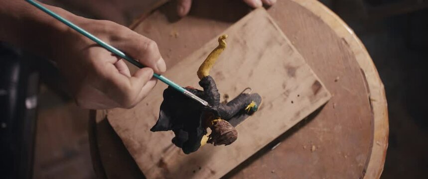 Artist finalize skateboarder sculpture art paintbrush paint  hand pov