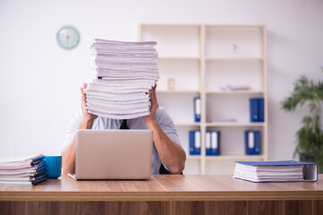 Young businessman employee unhappy with excessive work in the office