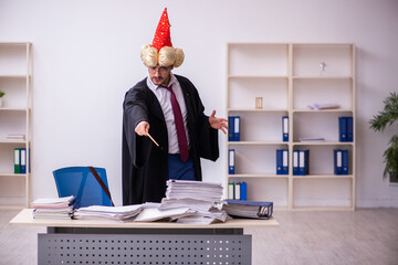 Funny young male employee magician and too much work in the office