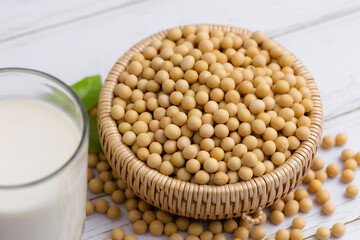Soy and soy milk in a glass with soybeans in wooden bowl background