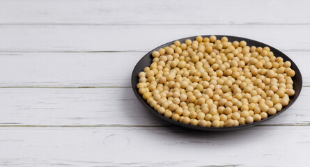 Soybean or soya bean in a bowl on white table background, healthy concept.