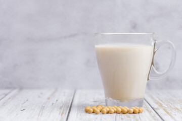 Soy milk and Soybeans on wooden table background. Healthy food Concept.