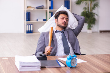 Young male employee in oversleeping concept