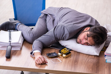 Young male employee in oversleeping concept