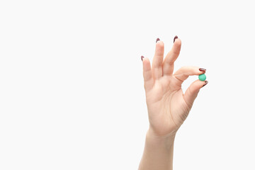 Girl holding a pill. Vitamins concept. Beautiful portrait on white background. Medicine home...