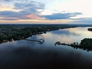 Aerial view sunset on the river. Colorful clouds are reflected in the water. Beautiful panorama of nature at sunset.