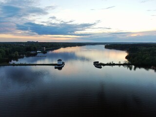 Aerial view sunset on the river. Colorful clouds are reflected in the water. Beautiful panorama of nature at sunset.