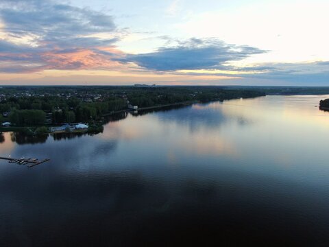 Aerial view sunset on the river. Colorful clouds are reflected in the water. Beautiful panorama of nature at sunset.