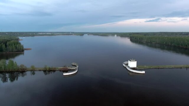 Aerial view flight at sunset above the river. Colorful clouds are reflected in the water. Beautiful panorama of nature at sunset.