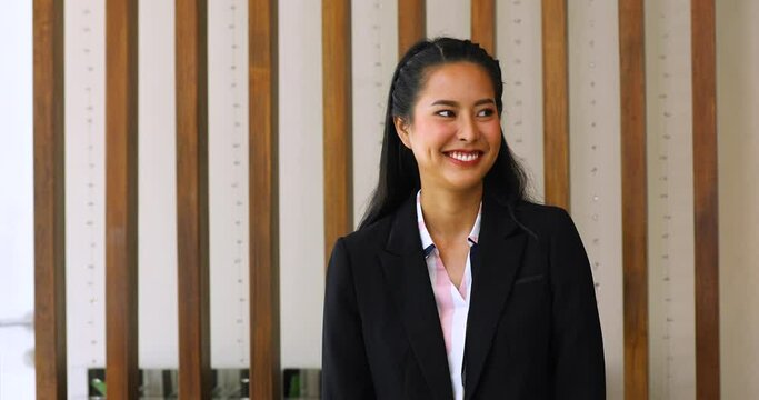 Friendly receptionist woman working at desk in hotel lobby