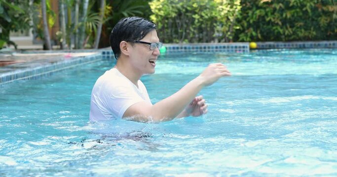 Asian father with little son in swimmingpool at park. Family Leisure and travel at holidays...