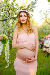 Fototapeta na wymiar Smiling pregnant woman in rural landscape. Beautiful pregnant woman relaxing in the park. Happy pregnant woman in pink dress looking at sunrise. Enjoying healthy pregnancy. Maternity, pregnancy care.
