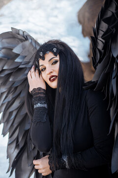 beautiful portrait of a young brunette woman dressed as a black angel
