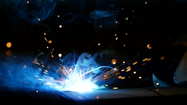 Man works circular saw. Craftsman sawing metal with disk grinder in workshop