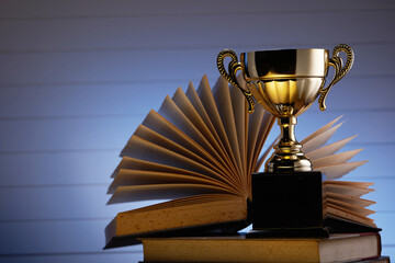 trophy on top stack of books