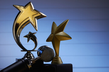 microphone and golden trophy against blue background
