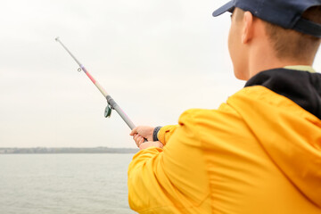 Teenage boy fishing on river, closeup