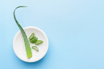 Plate with fresh cut aloe on color background