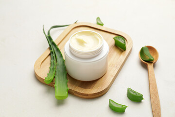 Natural cream with aloe leaves on light background