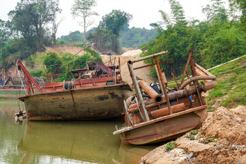 Fototapeta na wymiar Abandoned fishing tool ship stranded on the river beach