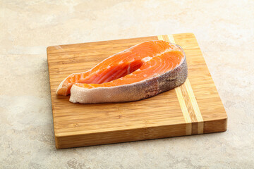 Raw salmon steak over board