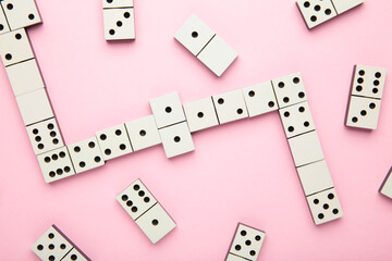 Playing dominoes on a pink background . Domino effect