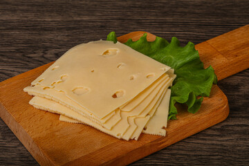 Sliced yellow cheese over board